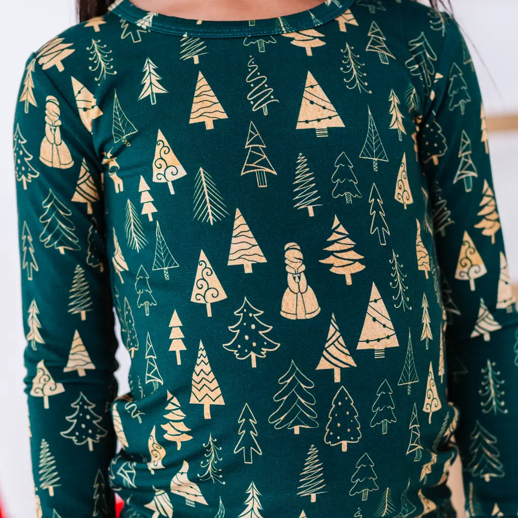 Close up of the front of a long sleeve pajama top in a dark green print of gold Christmas trees.